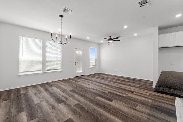unfurnished dining area with recessed lighting, visible vents, dark wood-type flooring, and ceiling fan with notable chandelier
