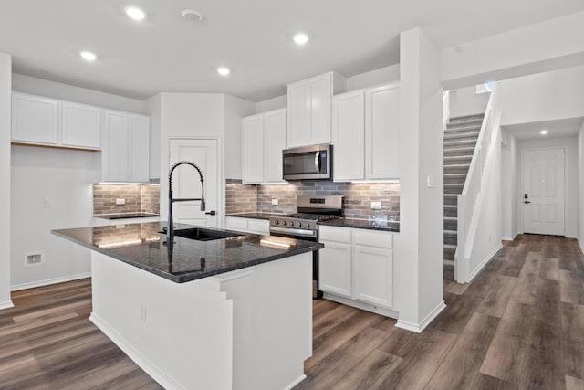 kitchen with dark wood finished floors, tasteful backsplash, appliances with stainless steel finishes, and a sink