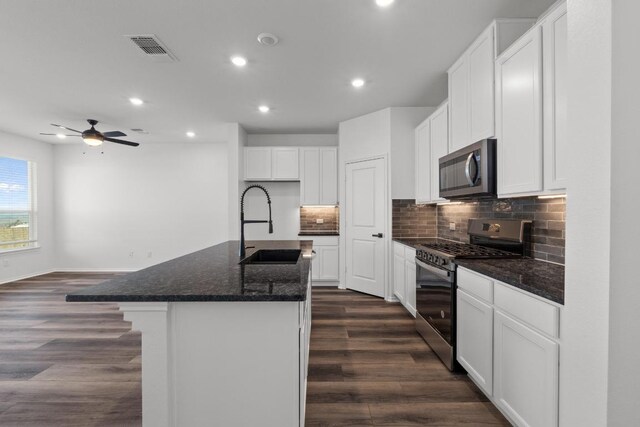 4829 Mozzafiato Ln, Round Rock, TX 78665 - kitchen with stainless steel appliances, recessed lighting, dark wood-style floors, backsplash, and dark stone counters