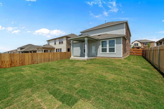 back of house with a yard, a patio area, and a fenced backyard