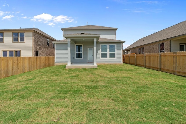 back of house featuring a yard, a patio, and a fenced backyard