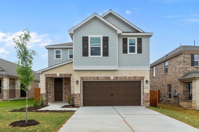 4829 Mozzafiato Ln, Round Rock, TX 78665 - view of front of home with driveway, an attached garage, stone siding, and a front lawn