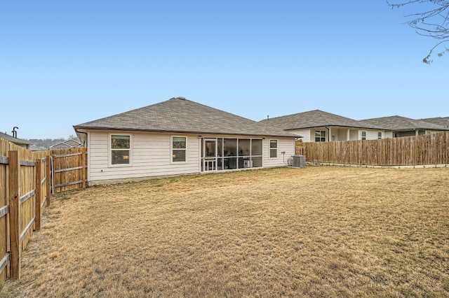 rear view of house with cooling unit and a lawn