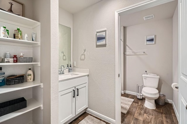 bathroom featuring vanity, wood-type flooring, and toilet