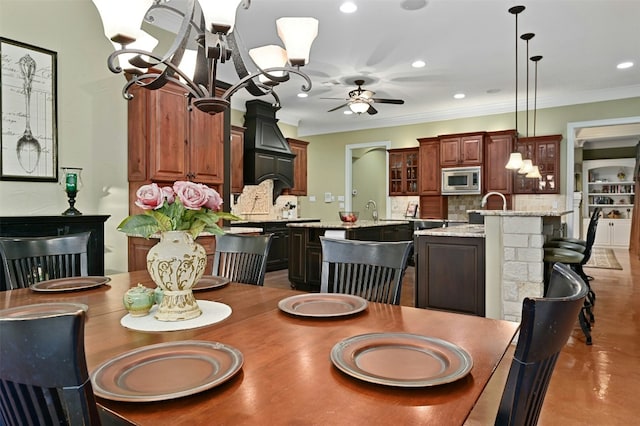 dining room with crown molding and ceiling fan with notable chandelier