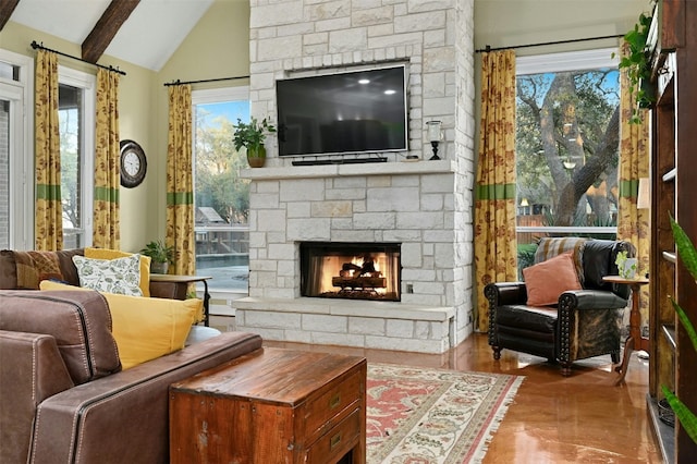 living area featuring a healthy amount of sunlight, a fireplace, and lofted ceiling with beams