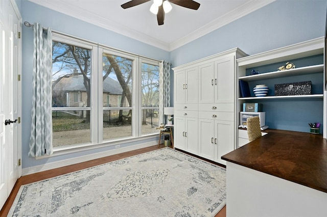 unfurnished office with crown molding, wood-type flooring, and ceiling fan