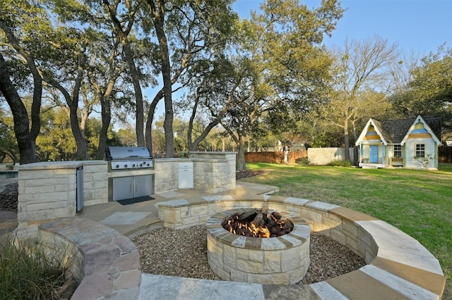 view of patio with an outbuilding, area for grilling, exterior kitchen, and a fire pit