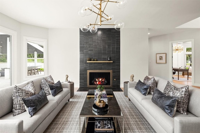 living area with plenty of natural light, a fireplace, and a notable chandelier