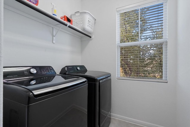 laundry room with separate washer and dryer and light tile patterned floors