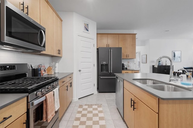 kitchen with sink, appliances with stainless steel finishes, a center island with sink, decorative backsplash, and light brown cabinets