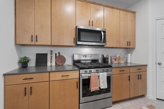 kitchen featuring tasteful backsplash, appliances with stainless steel finishes, light tile patterned floors, and light brown cabinets