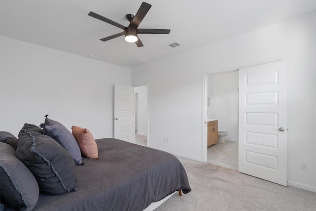 carpeted bedroom featuring ceiling fan and ensuite bath