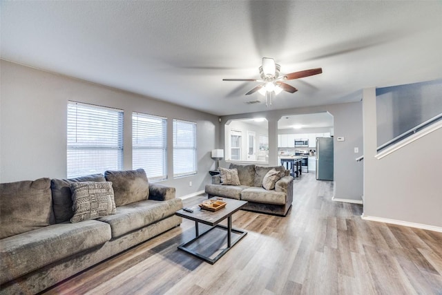 living room with ceiling fan and light hardwood / wood-style floors