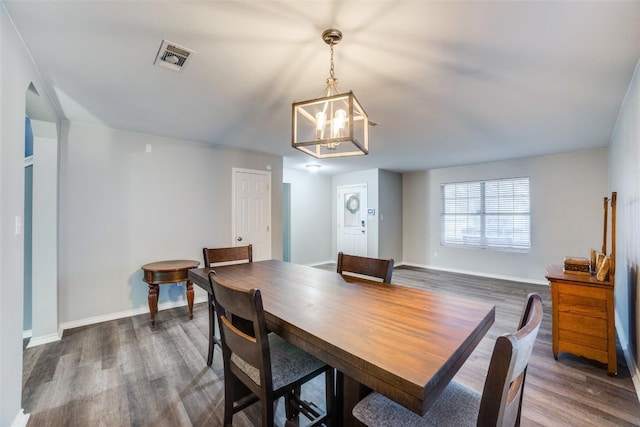 dining space featuring an inviting chandelier and dark hardwood / wood-style floors