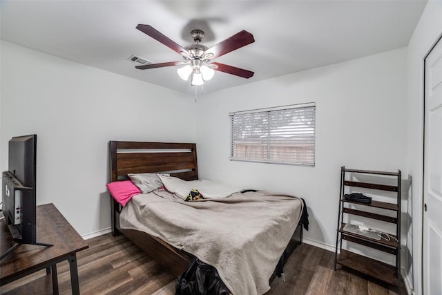 bedroom with dark hardwood / wood-style flooring and ceiling fan