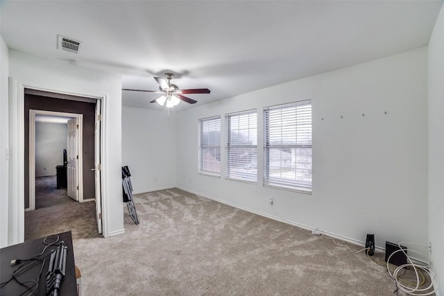 spare room featuring light carpet and ceiling fan