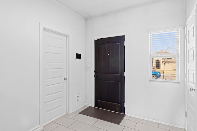 foyer featuring light tile patterned floors and baseboards