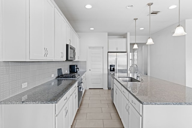 11813 Carrizo Springs Path, Manor, TX 78653 - kitchen featuring stainless steel appliances, backsplash, white cabinetry, an island with sink, and recessed lighting