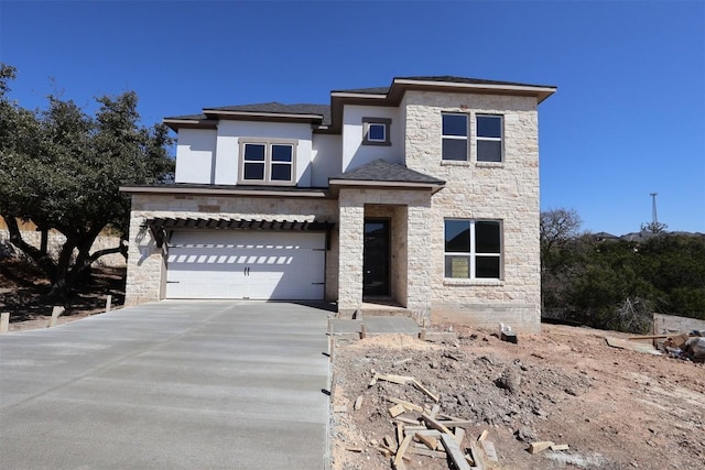 view of front of home with a garage, driveway, stone siding, and stucco siding