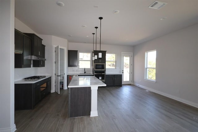 kitchen featuring visible vents, a sink, light countertops, appliances with stainless steel finishes, and a center island