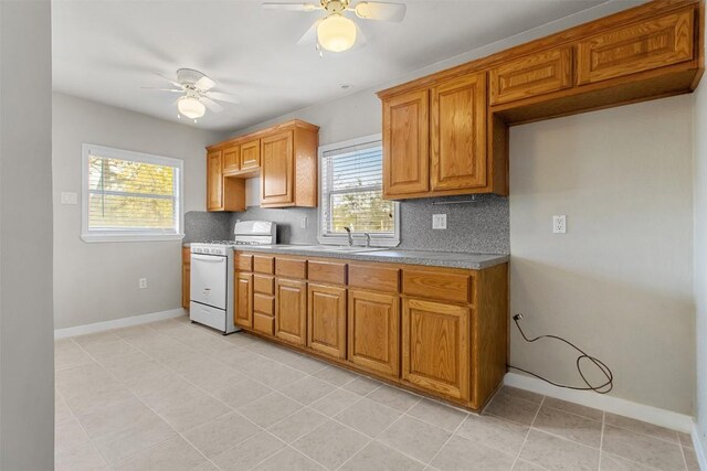 501 Hill St, Copperas Cove, TX 76522 - kitchen featuring gas range gas stove, ceiling fan, tasteful backsplash, and brown cabinetry