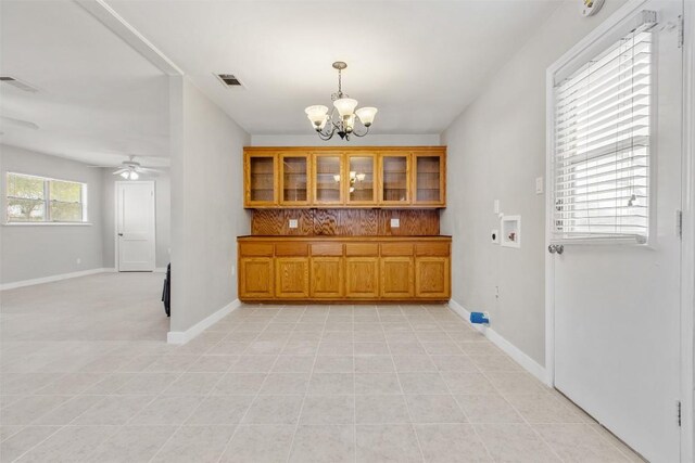 501 Hill St, Copperas Cove, TX 76522 - kitchen with brown cabinets, a chandelier, tasteful backsplash, glass insert cabinets, and pendant lighting