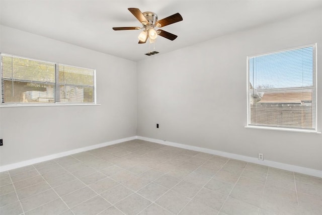 unfurnished room featuring ceiling fan and a wealth of natural light