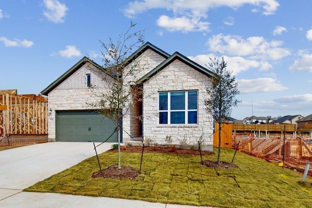 view of front of property featuring driveway, stone siding, and a front yard