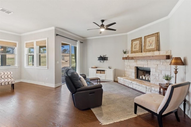 216 Fairlake Cir, Austin, TX 78734 - living room featuring a ceiling fan, crown molding, dark wood-style flooring, and a stone fireplace