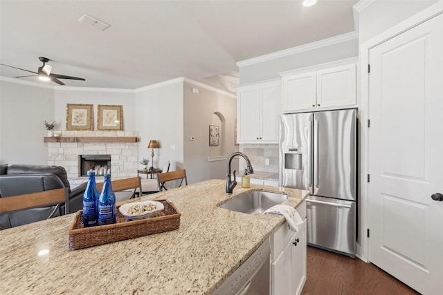 216 Fairlake Cir, Austin, TX 78734 - kitchen featuring stainless steel fridge, a ceiling fan, crown molding, white cabinetry, and light stone countertops
