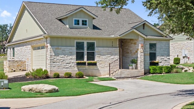216 Fairlake Cir, Austin, TX 78734 - craftsman-style house with stone siding, a front lawn, roof with shingles, and an attached garage