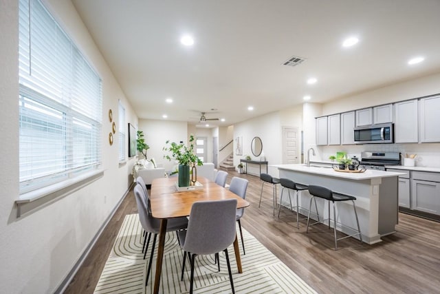 dining space featuring dark wood-type flooring, ceiling fan, and sink