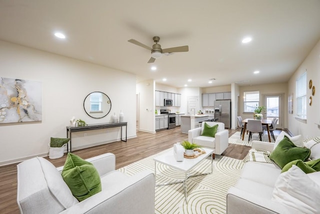 living room featuring light hardwood / wood-style flooring and ceiling fan