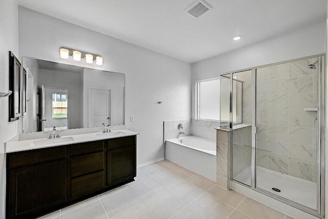 bathroom featuring a bath, double vanity, a sink, and a stall shower