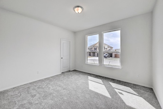 unfurnished room with baseboards and carpet