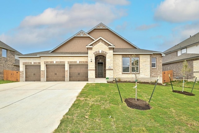 view of front facade with concrete driveway, roof with shingles, an attached garage, stone siding, and a front lawn