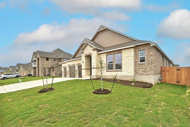view of front facade featuring fence, stone siding, driveway, a front lawn, and a garage