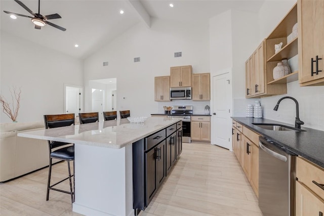 18208 Gregg Bluff Rd, Jonestown, TX 78645 - kitchen featuring stainless steel appliances, a breakfast bar, open shelves, high vaulted ceiling, and light brown cabinets