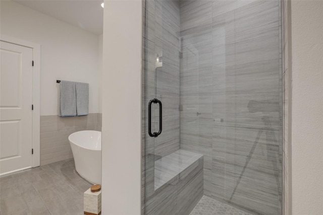 18208 Gregg Bluff Rd, Jonestown, TX 78645 - full bath with a freestanding bath, tile walls, a shower stall, and wainscoting