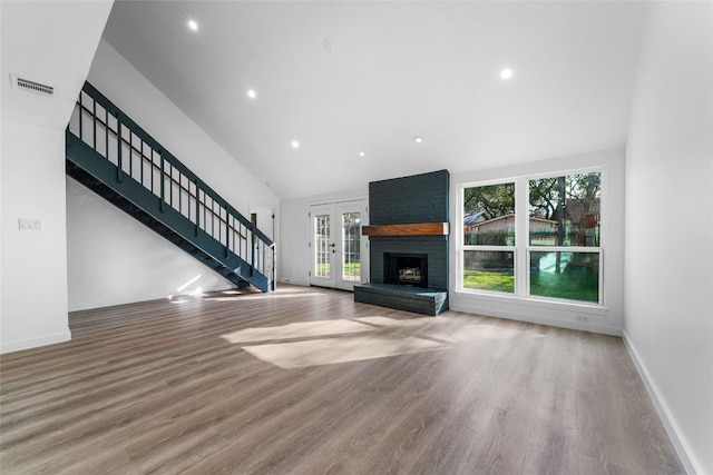 3507 Lovage Dr, Austin, TX 78727 - unfurnished living room with french doors, stairway, wood finished floors, high vaulted ceiling, and recessed lighting