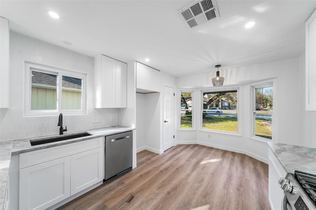 3507 Lovage Dr, Austin, TX 78727 - kitchen with stainless steel appliances, white cabinetry, light wood-style floors, recessed lighting, and light stone counters