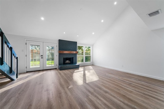 3507 Lovage Dr, Austin, TX 78727 - unfurnished living room featuring french doors, high vaulted ceiling, recessed lighting, wood finished floors, and stairway