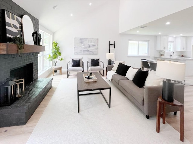 3507 Lovage Dr, Austin, TX 78727 - living room featuring recessed lighting, a fireplace, high vaulted ceiling, and light wood-style floors