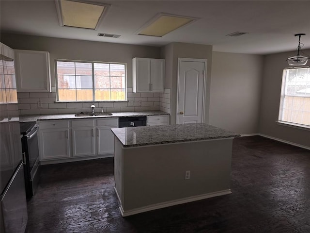 kitchen featuring white cabinetry, black dishwasher, sink, hanging light fixtures, and a center island