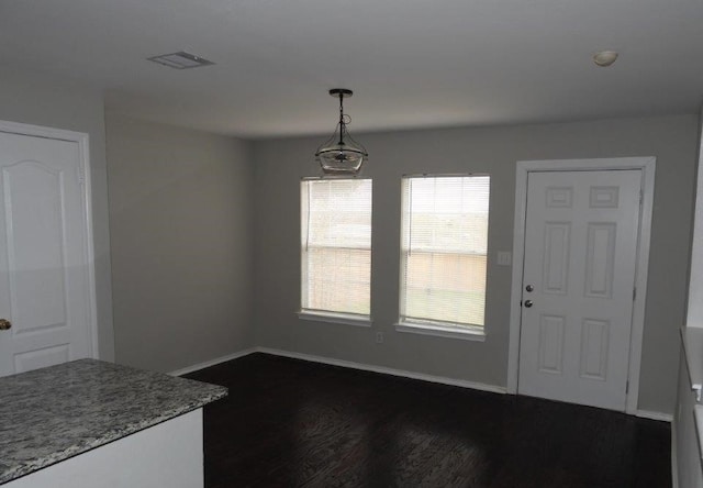 unfurnished dining area featuring dark hardwood / wood-style flooring