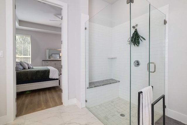 ensuite bathroom with marble finish floor, connected bathroom, a shower stall, and baseboards