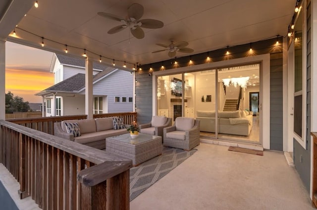 patio terrace at dusk with outdoor lounge area and ceiling fan