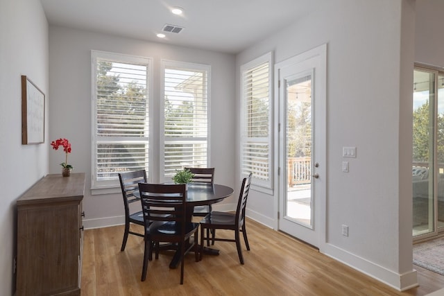 dining room with visible vents, light wood-style flooring, and baseboards