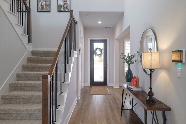 foyer featuring visible vents, baseboards, and wood finished floors